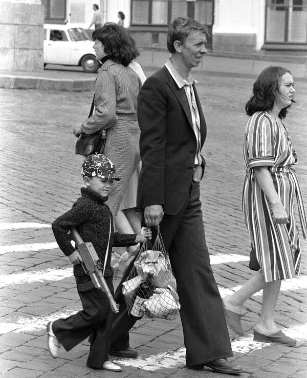 Советский мальчик с игрушечным пулеметом идет по Красной площади с отцом, держась за продуктовую сумку с товарами. - Sputnik Беларусь