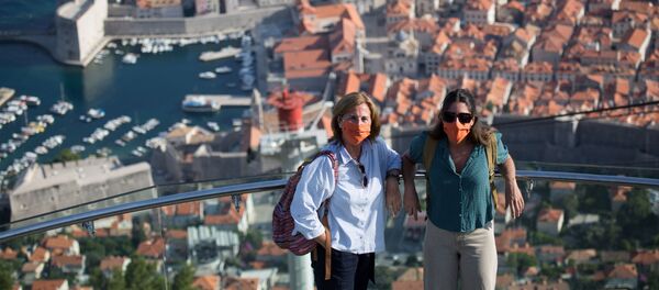 Туристы в защитных масках позируют на верхней станции канатной дороги над старым городом Дубровником в Хорватии - Sputnik Беларусь