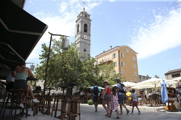 Туристы гуляют перед церковью Сен-Жан-Батист на главной площади старого города Порто-Веккио, на французском средиземноморском острове Корсика - Sputnik Беларусь