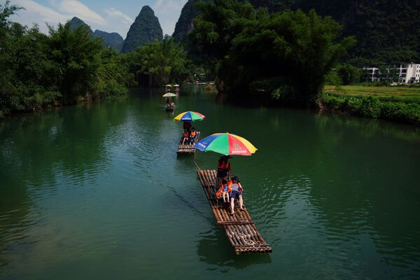 Туристы катаются на плотах по реке Юлонг в округе Яншо, Гуанси-Чжуанский автономный район, Китай - Sputnik Беларусь