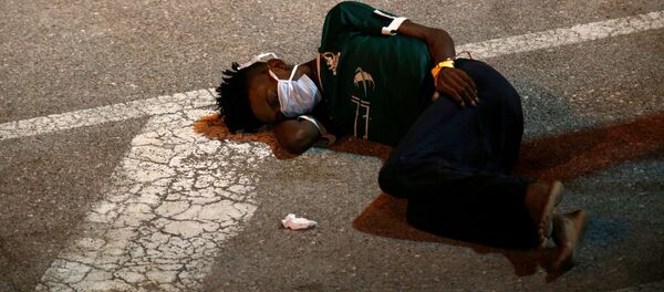 Спасенный вооруженными силами Мальты мигрант лежит на земле - Sputnik Беларусь