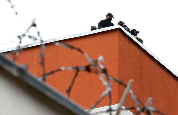 Военнослужащие МВД Беларуси наблюдают с крыши следственного изолятора в Минске - Sputnik Беларусь