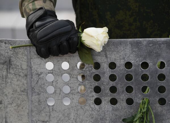 Цветок в руке военнослужащего на акции протеста в Минске. - Sputnik Беларусь