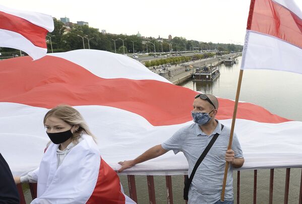 Жители Варшавы держат белорусские флаги в знак поддержки протестов в соседней Беларуси  - Sputnik Беларусь