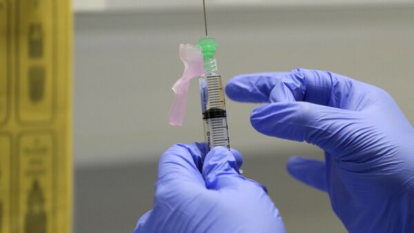 Медсястра рыхтуе вакцыну ад COVID-19 для ўвядзення добраахвотніку ў клініцы ў Лондане - Sputnik Беларусь