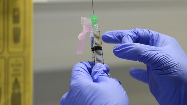 Медсястра рыхтуе вакцыну ад COVID-19 для ўвядзення добраахвотніку ў клініцы ў Лондане - Sputnik Беларусь