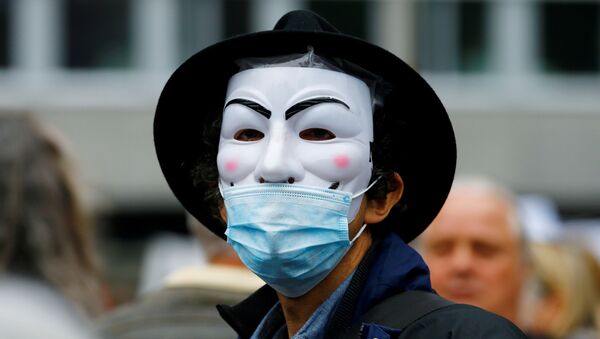 Демонстрант в маске Гая Фокса во время акции протеста против мер по замедлению распространения COVID-19 в Цюрихе - Sputnik Беларусь