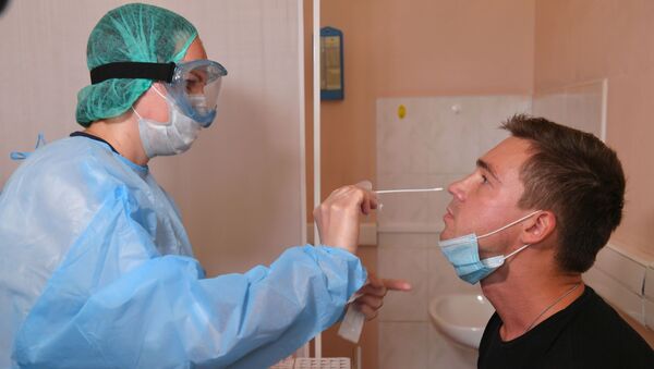 Пациент во время взятия мазка на коронавирус COVID-19  - Sputnik Беларусь