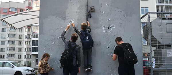 Местные жители очищают стену в жилом дворе на улице Червякова, который назвали Площадью перемен в Минске - Sputnik Беларусь