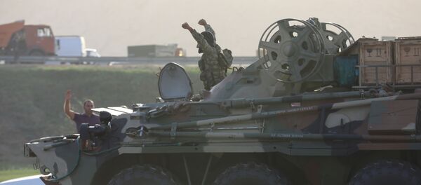 Военнослужащий Азербайджана управляет бронетранспортером и приветствует граждан, собравшихся на обочине дороги в Баку - Sputnik Беларусь