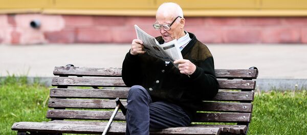 Мужчина читает газету на улице на лавочке  - Sputnik Беларусь