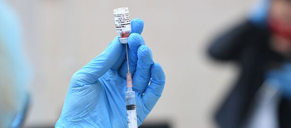 Медыцынская сястра трымае ў руках вакцыну Медыцынская сястра трымае ў руках вакцыну - Sputnik Беларусь