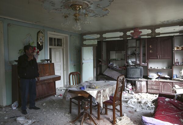 Местный житель в своем доме, поврежденном в результате обстрела в Тертерском районе - Sputnik Беларусь