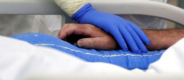Медык трымае за руку пацыента, хворага на каронавірус Медык трымае за руку пацыента, хворага на каронавірус - Sputnik Беларусь