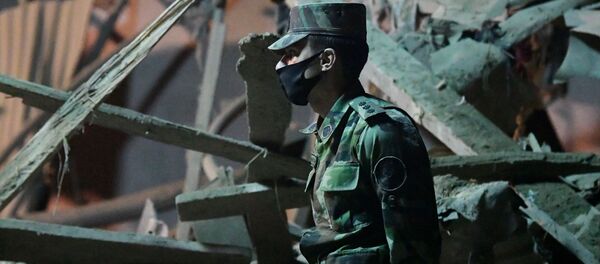 Военнослужащий на месте разбора завалов разрушенных домов после ракетного обстрела города Гянджа - Sputnik Беларусь