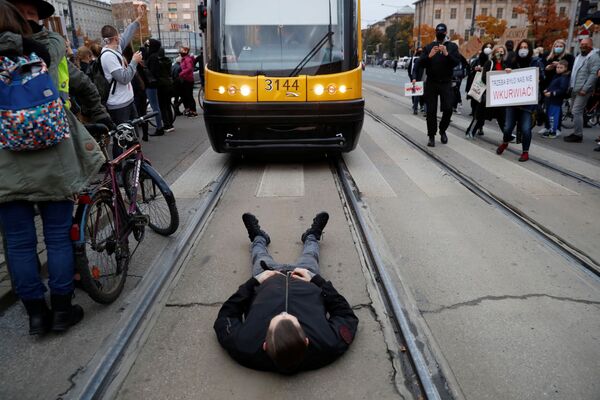 Протестующий лежит на трамвайных путях в Варшаве в время блокировки дорог 26 октября в Польше - Sputnik Беларусь