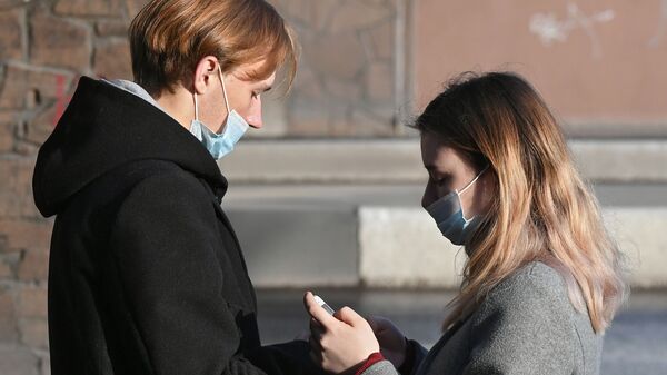 Молодые люди в защитных масках на улице - Sputnik Беларусь