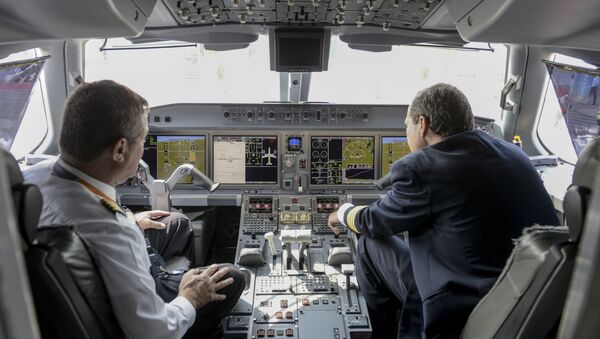 Члены экипажа сидят в кабине самолета Embraer E195-E2 - Sputnik Беларусь