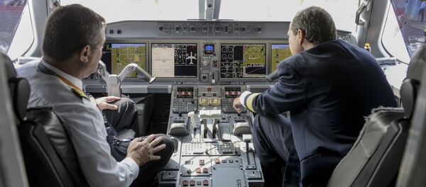 Члены экипажа сидят в кабине самолета Embraer E195-E2 - Sputnik Беларусь