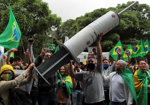 Демонстранты несут гигантский шприц во время протеста в Бразилии - Sputnik Беларусь