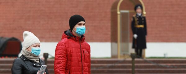 Люди в защитных масках в Александровском саду в Москве Люди в защитных масках в Александровском саду в Москве - Sputnik Беларусь