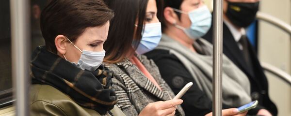 Люди в защитных масках в вагоне Московского метрополитена - Sputnik Беларусь