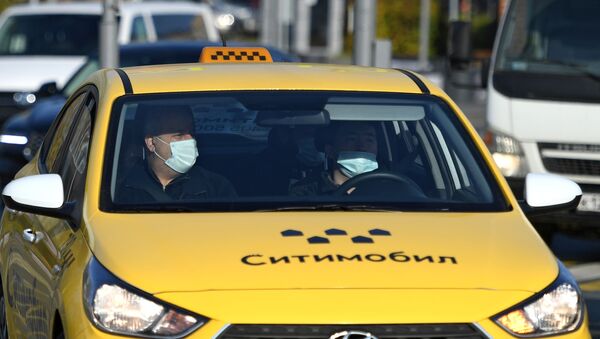 Пассажир в защитной маске едет в такси - Sputnik Беларусь