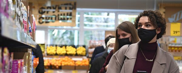 Жанчыны ў ахоўнай масцы выбіраюць прадукты - Sputnik Беларусь