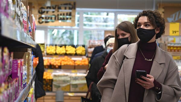 Женщины в защитной маске выбирают продукты - Sputnik Беларусь