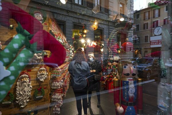 Покупательница разговаривает с продавщицей в полупустом магазине рождественских украшений в Риме - Sputnik Беларусь