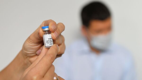 Медицинский работник демонстрирует вакцину против COVID-19 - Sputnik Беларусь