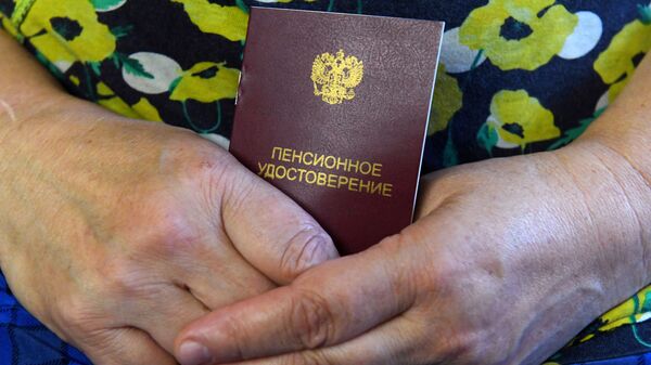 Пенсионерка держит пенсионное удостоверение - Sputnik Беларусь