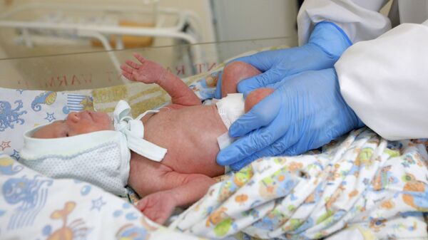 Медицинский работник и новорожденный ребенок в акушерском отделении ковид-госпиталя - Sputnik Беларусь