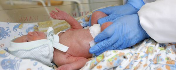 Медицинский работник и новорожденный ребенок в акушерском отделении ковид-госпиталя - Sputnik Беларусь