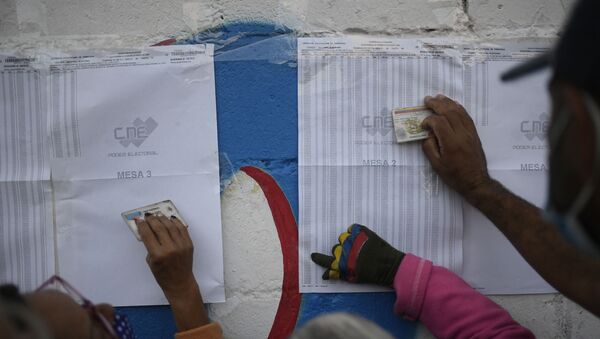 Избиратели проверяют свои избирательные участки во время выборов членов Национального собрания в Каракасе - Sputnik Беларусь