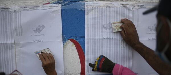 Избиратели проверяют свои избирательные участки во время выборов членов Национального собрания в Каракасе - Sputnik Беларусь