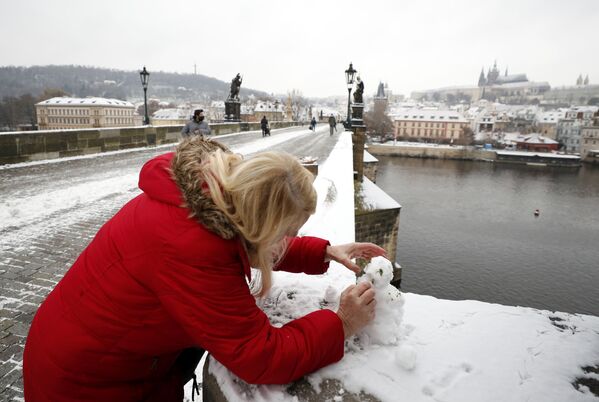 Женщина лепит снеговика на Карловом мосту в Праге, Чехия - Sputnik Беларусь