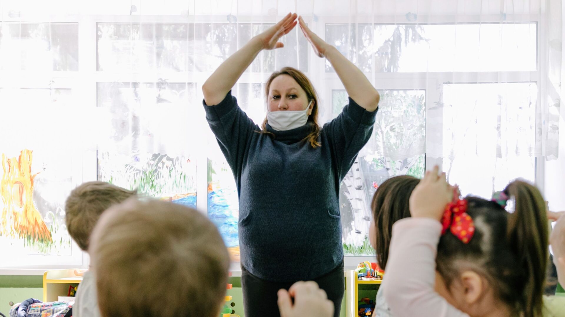 Воспитатель в медицинской маске играет с детьми в детском саду - Sputnik Беларусь, 1920, 01.06.2022