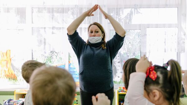 Воспитатель в медицинской маске играет с детьми в детском саду - Sputnik Беларусь