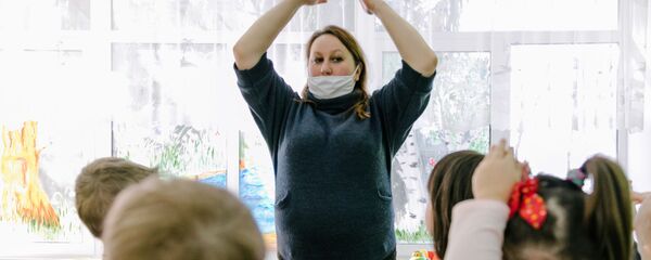 Воспитатель в медицинской маске играет с детьми в детском саду - Sputnik Беларусь