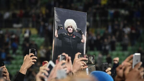 Люди держат фото российского бойца Хабиба Нурмагомедова - Sputnik Беларусь