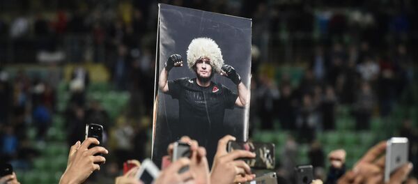 Люди держат фото российского бойца Хабиба Нурмагомедова - Sputnik Беларусь