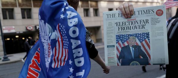 Продавец держит газету во время митинга в поддержку президента США Трампа в Вашингтоне, США, 14 ноября 2020 года Продавец держит газету во время митинга в поддержку президента США Трампа в Вашингтоне, США, 14 ноября 2020 года - Sputnik Беларусь