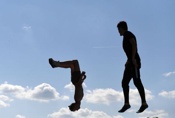 Молодые люди во время выполнения акробатических прыжков на территории спортивного комплекса Лужники в Москве - Sputnik Беларусь