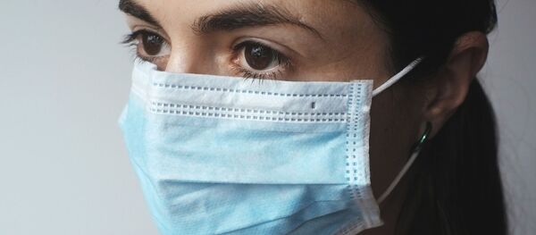 Девушка в защитной маске, архивное фото - Sputnik Беларусь