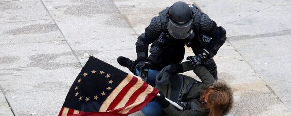 Паліцэйскі затрымлівае чалавека, які пратэстуе ля будынка Кангрэсу ў Вашынгтоне - Sputnik Беларусь