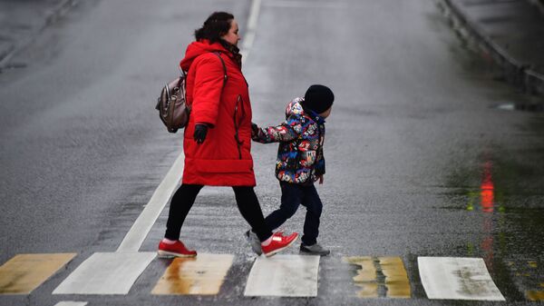 Женщина с ребенком идут по пешеходному переходу - Sputnik Беларусь