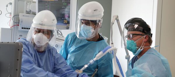 Врачи осматривают пациента в коронавирусном госпитале в Калифорнии Врачи осматривают пациента в коронавирусном госпитале в Калифорнии - Sputnik Беларусь