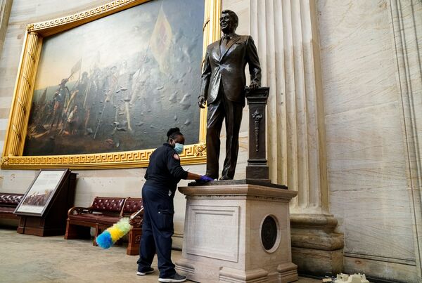 Работница чистит статую Рональда Рейгана в Ротонде Капитолия через день после штурма - Sputnik Беларусь