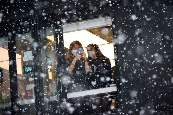 Девушки фотографируют снегопад в Сеуле  - Sputnik Беларусь